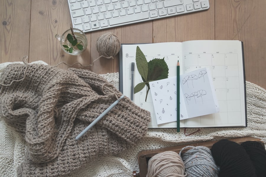 crocheted scarf sitting near a planner