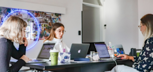 Women sitting around a shared desk planning a paid search strategy