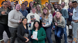 Team NetElixir group photo holding our company read, Traction.