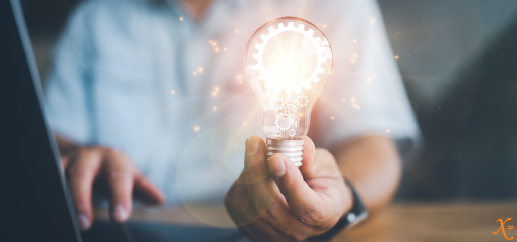 person on laptop holding a light bulb