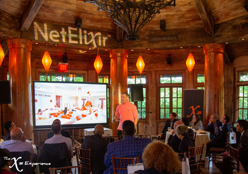 David Bell in a bright pink sweater sharing his presentation