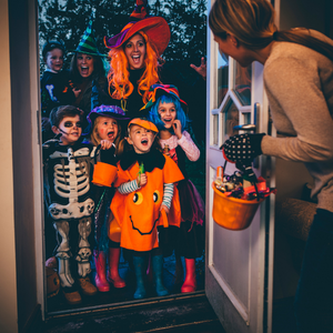 Group of kids and their parents trick-or-treating at someone's house
