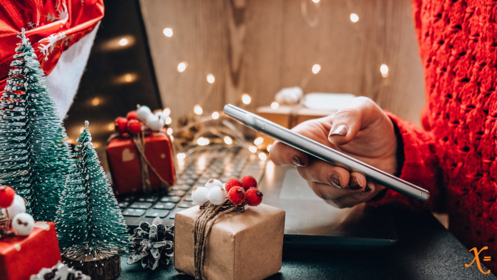 Holiday shopping on mobile phone, surrounded by holiday decor